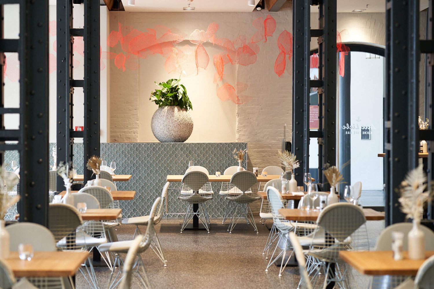 ein Restaurant mit Tischen und Stühlen und einer Pflanze in einer Vase von Alte Liebe Catering