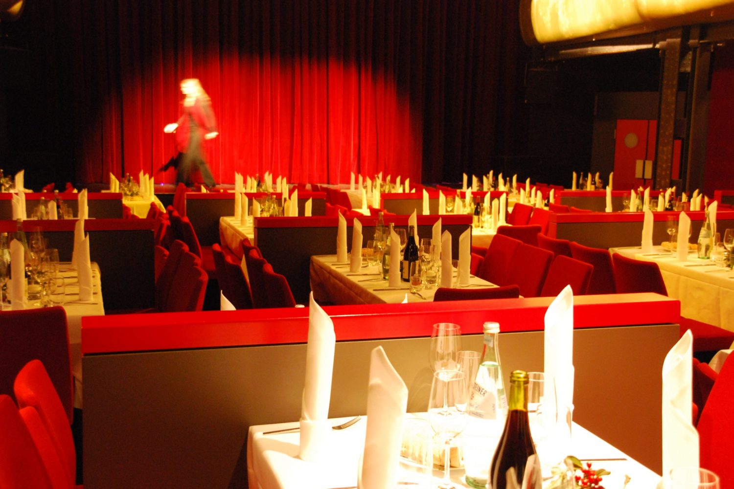 Theater Kehrwieder Elegantes Setup von Alte Liebe Catering für eine Veranstaltung mit gedeckten Tischen und rotem Theatervorhang.