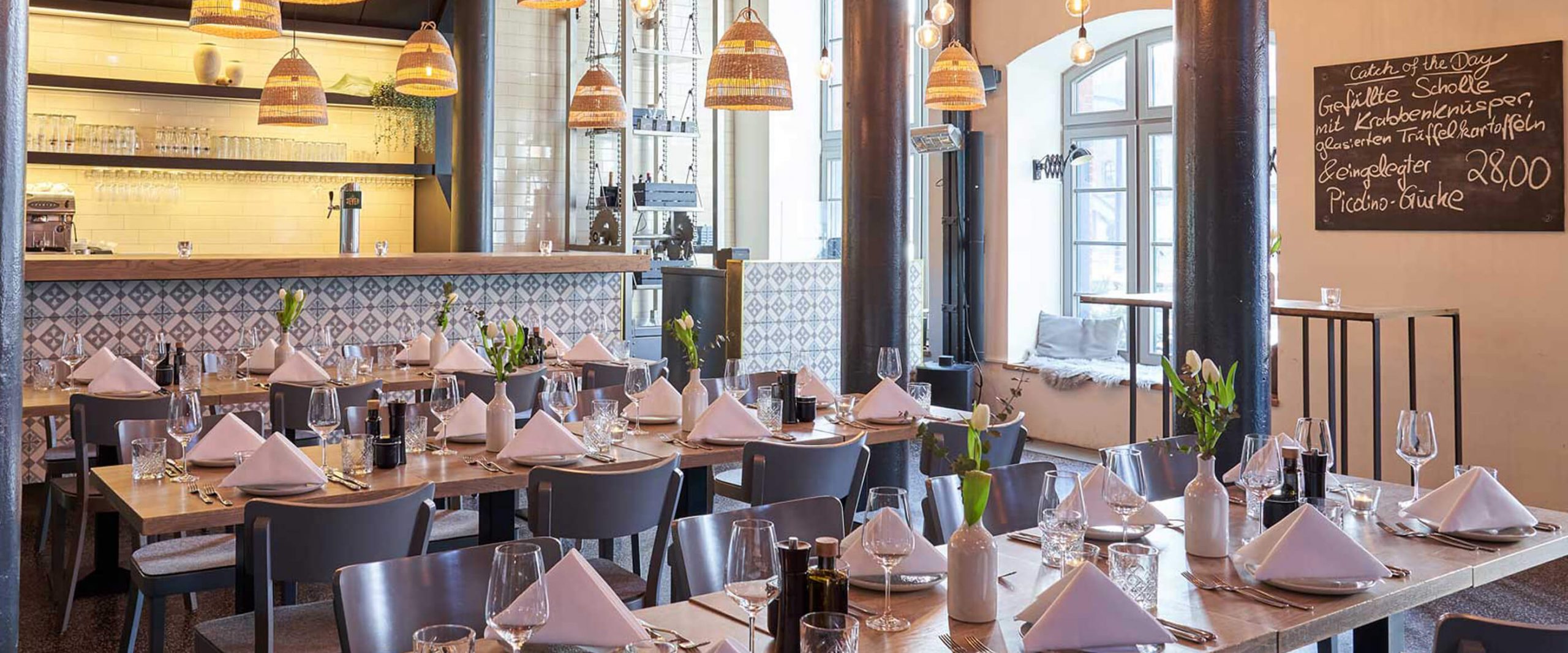 ein Speisesaal mit vielen Tischen und Stühlen, die für Alte Liebe Catering vorbereitet sind