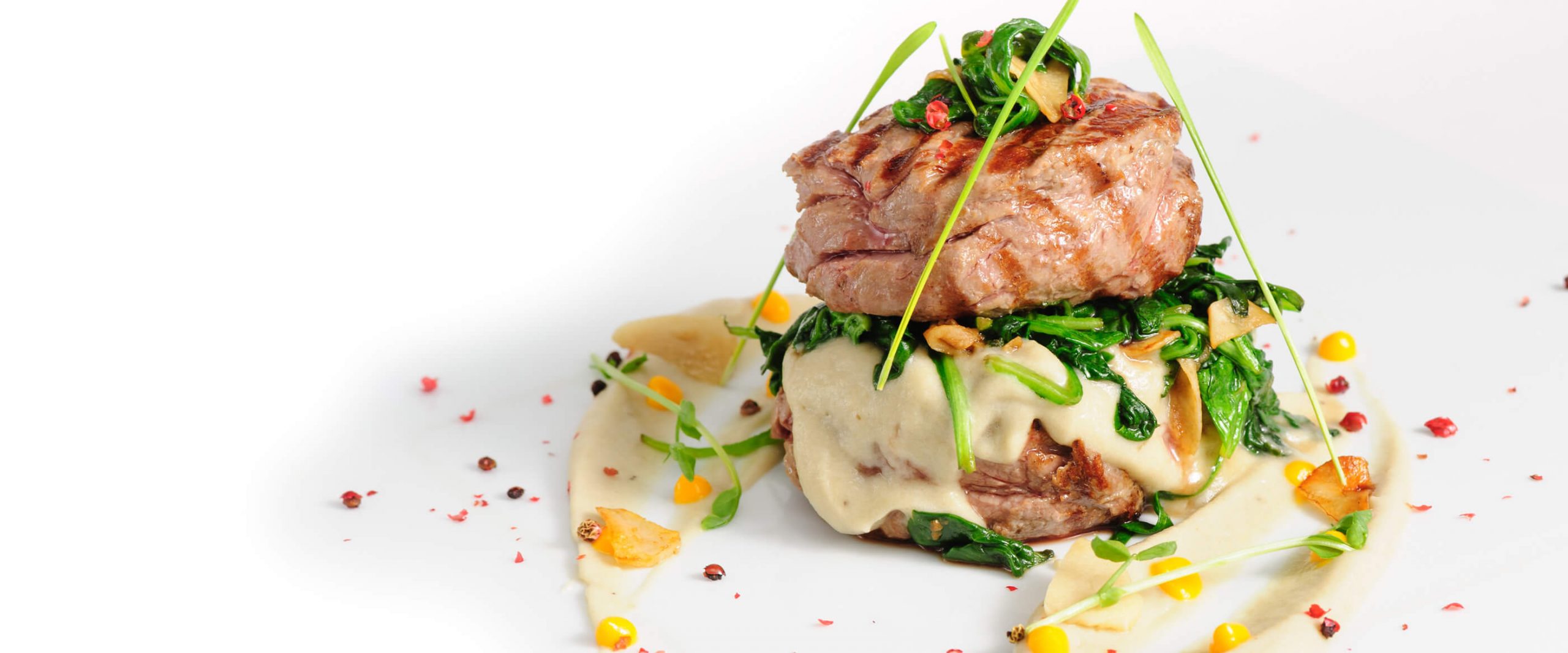 ein weißer Teller mit Fleisch, das mit Sauce von Alte Liebe Catering bedeckt ist